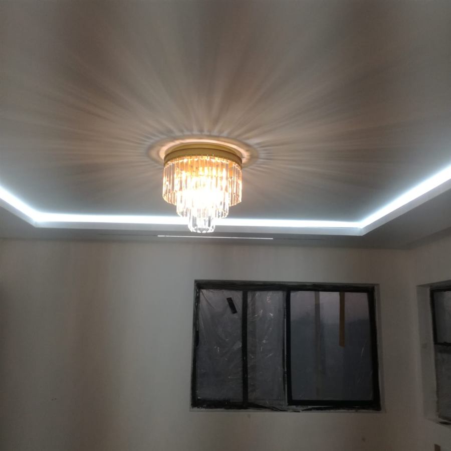 Ceiling cove with white LED strip lighting around a tiered crystal light fitting