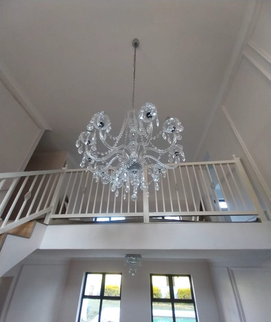 Crystal chandelier hanging in a double-volume entrance hall