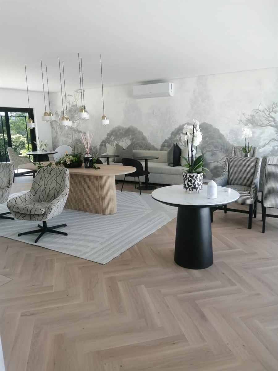 Lounge with a cluster of brass and white pendant lights above a dining table
