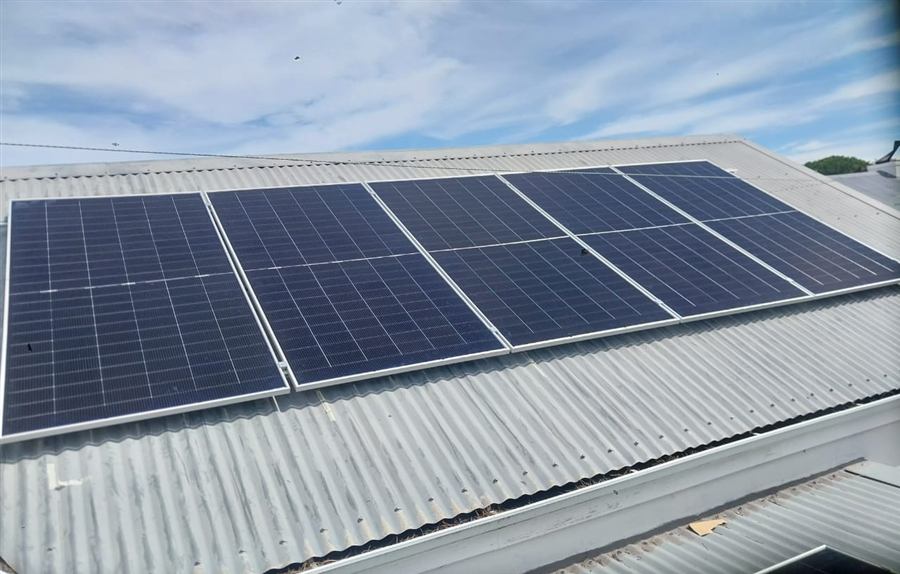 Row of solar panels mounted on a corrugated iron roof