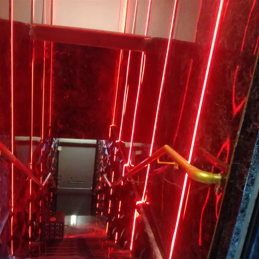 Stairwell with vertical red LED strip lighting on dark marble walls